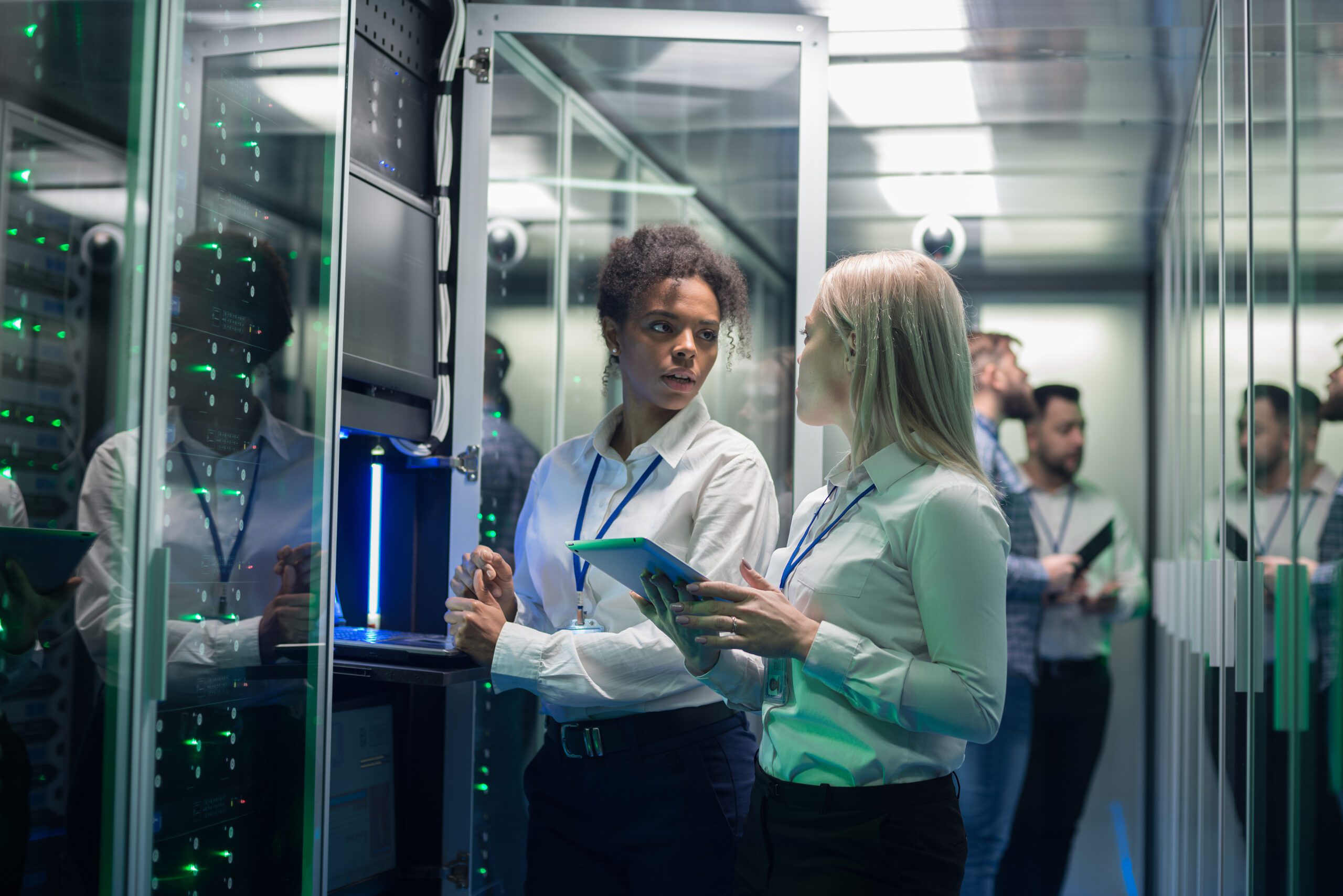 Two women are working in a data center with rows of server racks BITS GmbH